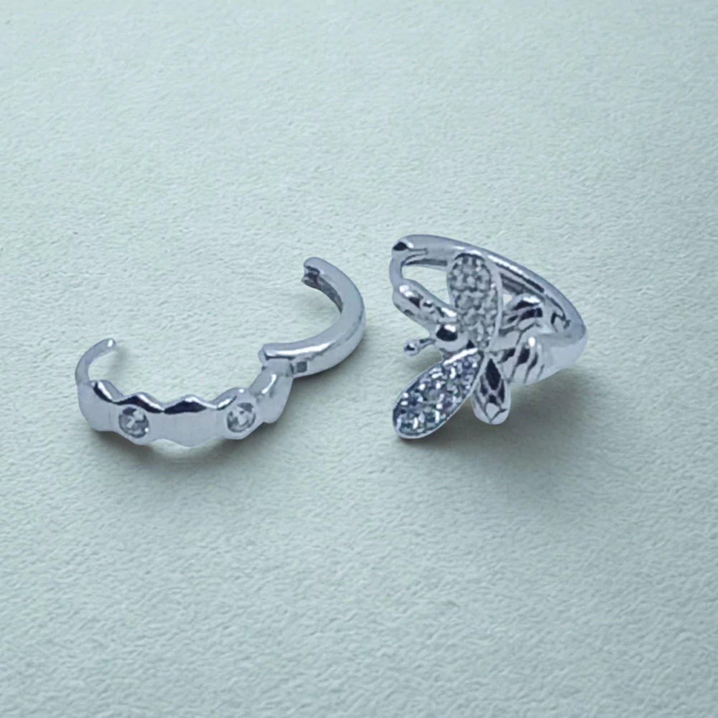 Sterling Silver Huggie Hoops Asymmetric design, bee earring and open honeycomb earring on a light background