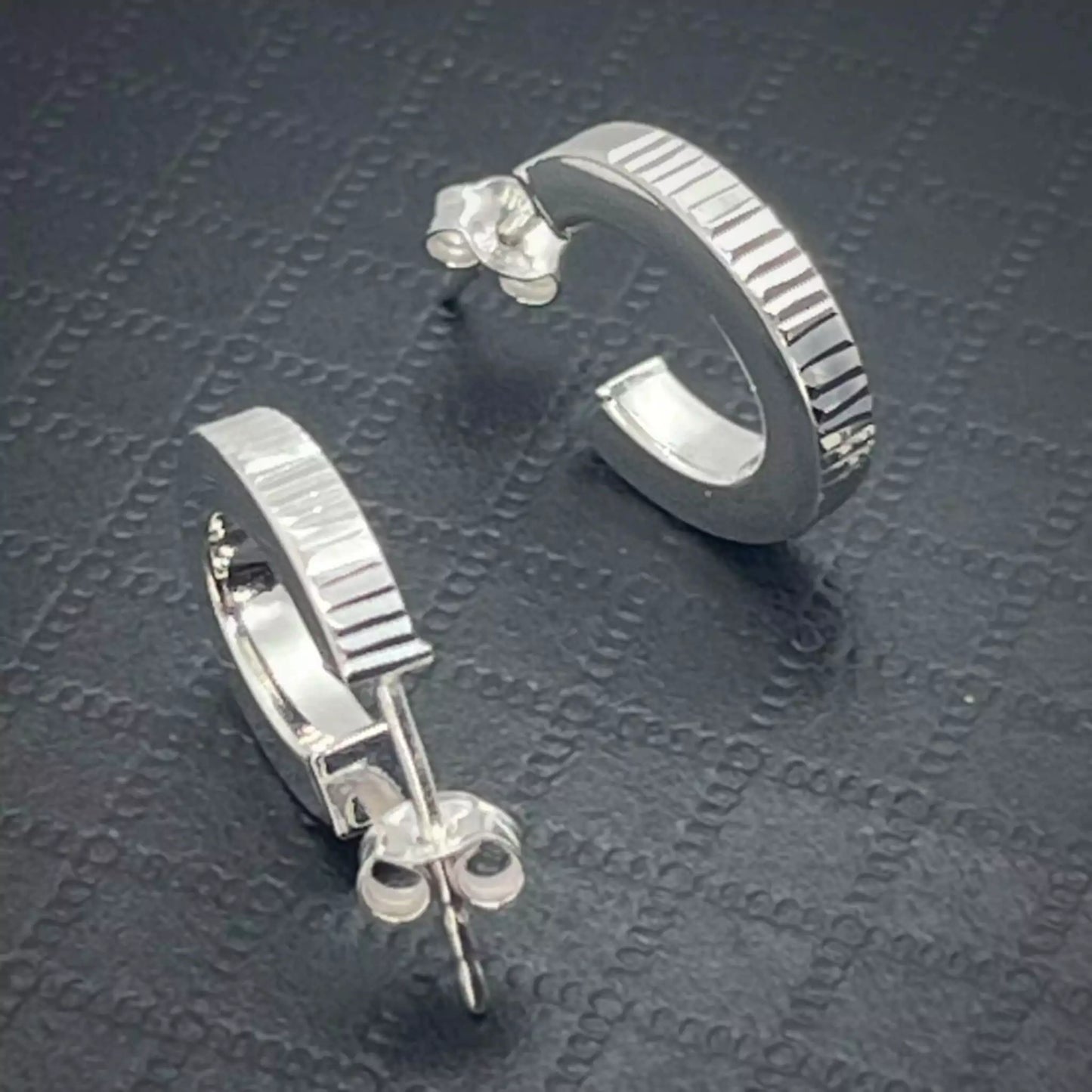 Pair of Stunning Ribbed Lobe Stud Hoop Sterling Silver Earrings on a textured dark surface