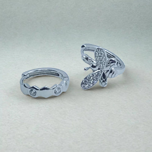Asymmetric Sterling Silver Huggie Hoop Earrings with sparkly zircon stones on a light gray background