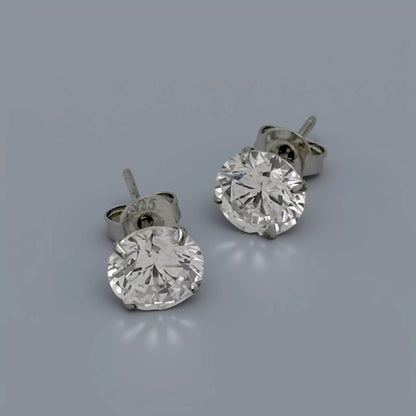 Silver stud earrings crafted in 925 sterling silver featuring clear white round cubic zirconia stones displayed on a smooth cool mid grey background with soft diffused lighting.