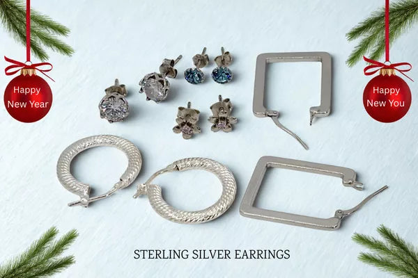 Collection of silver earrings on a light blue background with festive decorations.