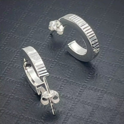 Pair of Lobe Hoop earrings crafted in Sterling Silver 925 on a textured dark surface.
