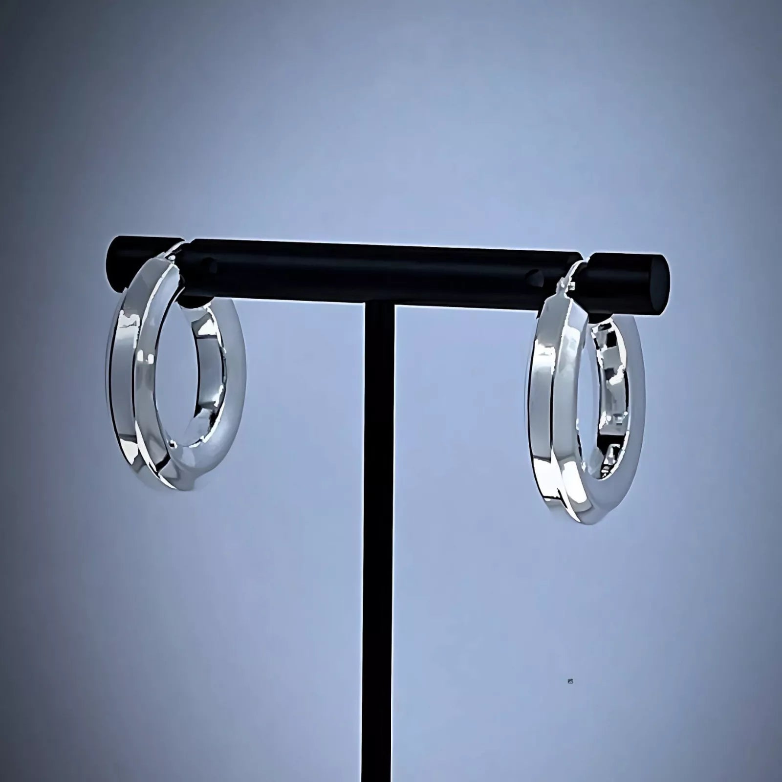 A pair of Chunky Sterling Silver 925 Hoop Earrings, tube-shaped Hexagon placed on a black background.
