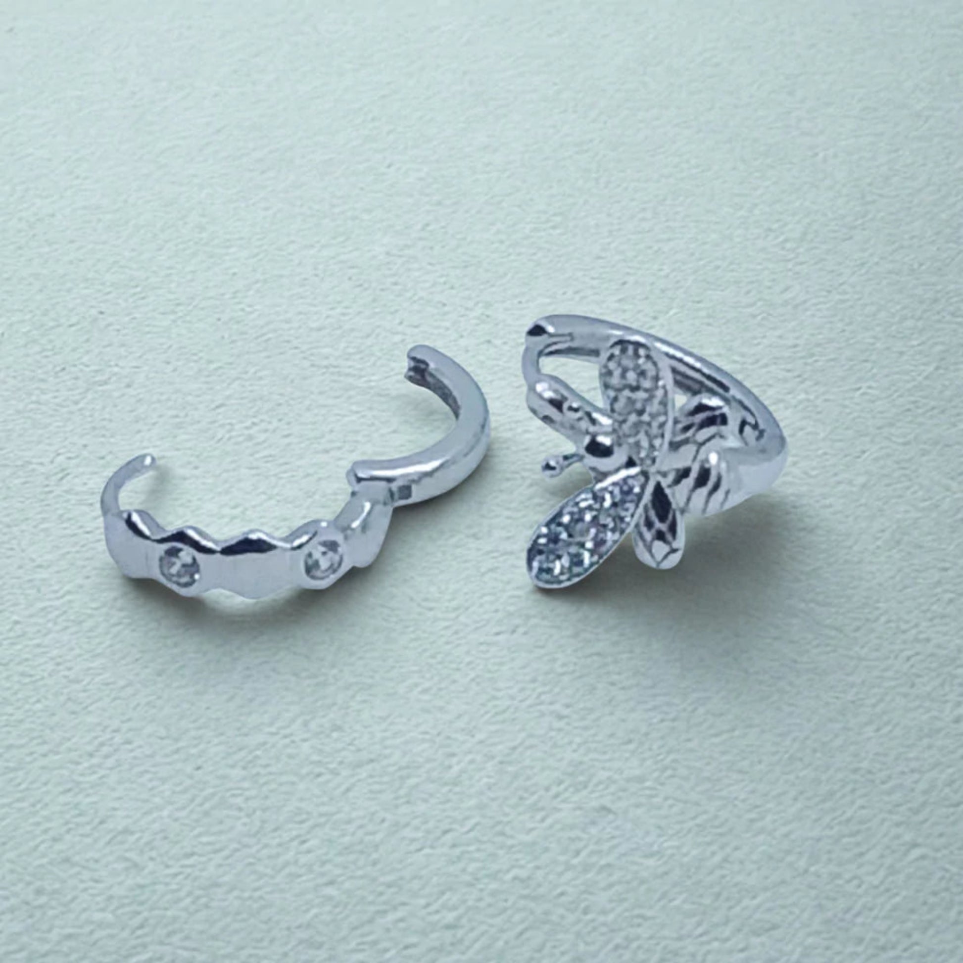 Sterling Silver Huggie Hoops Asymmetric design, bee earring and open honeycomb earring  on a light background